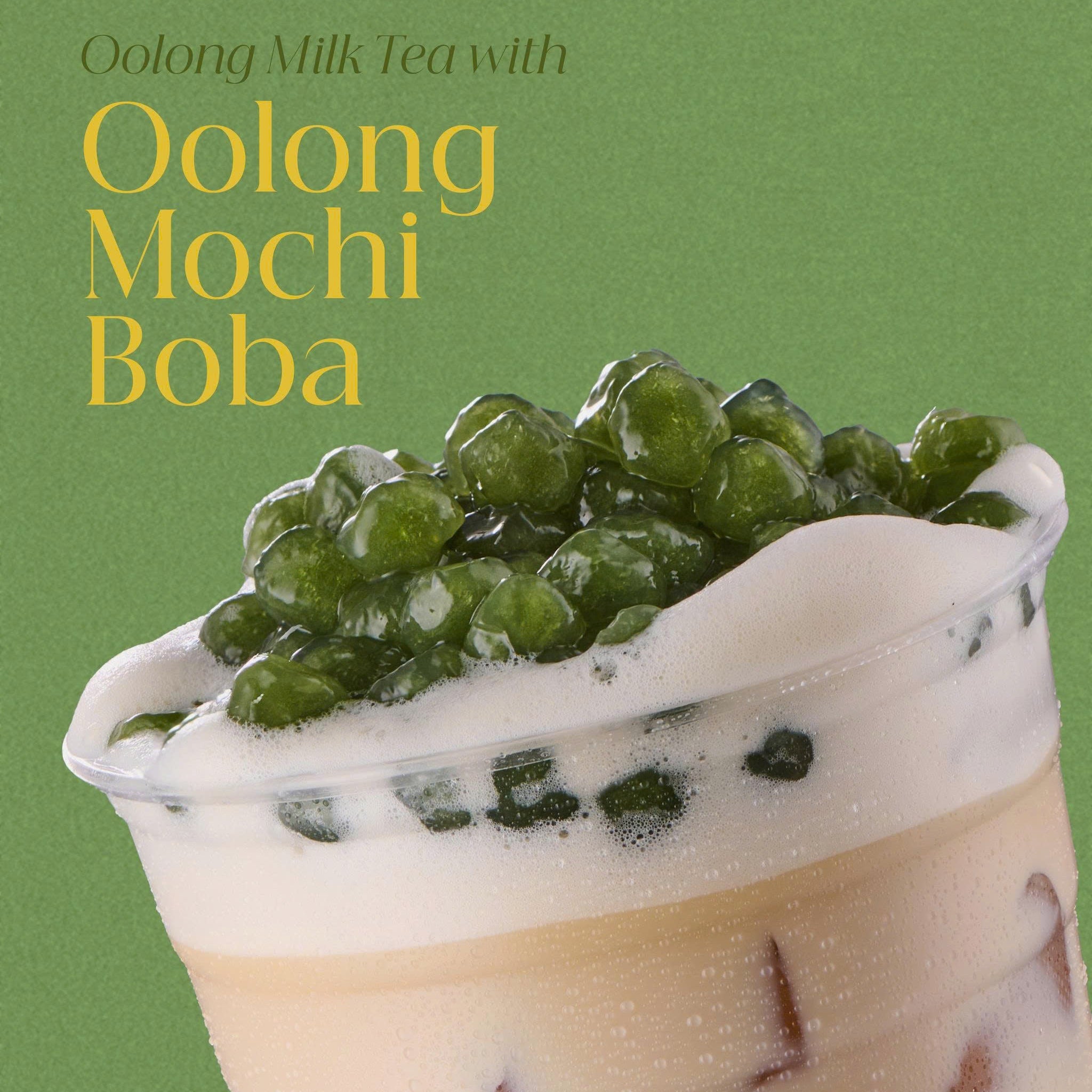Oolong milk tea with oolong mochi boba on a green background